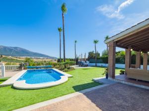 a backyard with a swimming pool and a lawn with palm trees at Cubo's Finca Tallulah in Villafranco de Guadalhorce