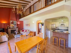 a kitchen and living room with a wooden table and chairs at Cubo's Finca Tallulah in Villafranco de Guadalhorce