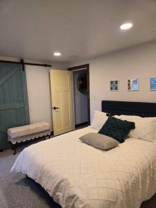 a bedroom with a large white bed and a door at Marysvale House by Bryce and Piute Trail in Marysvale +12 photos