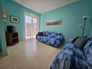 un soggiorno con due letti e un divano di Southern Comfort Sicily Holidays a Letoianni