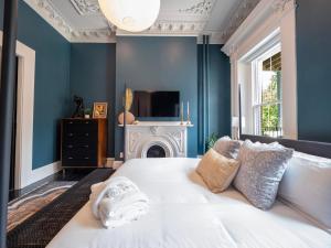 a bedroom with a white bed and a fireplace at The Chester Hotel in Boston