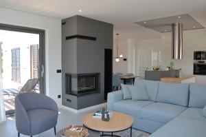 ein Wohnzimmer mit einer blauen Couch und einem Kamin in der Unterkunft Villa Ardura in Zaton