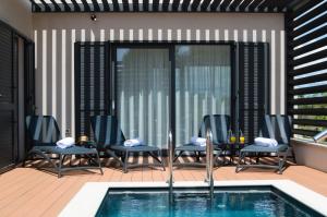 eine Terrasse mit Stühlen und einem Swimmingpool in der Unterkunft Villa Ardura in Zaton