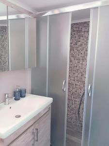 a bathroom with a sink and a shower at Kavala Penthouse in Kavala +16 photos