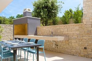 eine Terrasse mit Tisch und Stühlen und einem Waschbecken in der Unterkunft Villa Ardura in Zaton