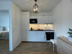a kitchen with white cabinets and a bed in a room at Apartment near to Paris CDG in Aulnay-sous-Bois +11 photos