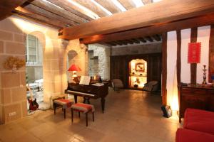 a living room with a piano and a living room with a fireplace at La Maison d'Anne in Paris