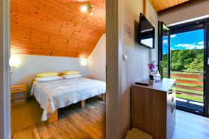 a small bedroom with a bed and a window at Apartment & Rooms Luketic in Rastovača