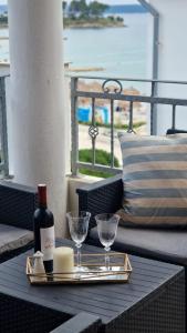 a tray with a bottle of wine and glasses on a table at Apartment Lučka in Rab