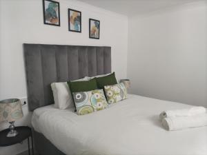 Un dormitorio con una gran cama blanca con almohadas. en Cethone Luxury Guest House, en Ciudad del Cabo