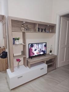 a living room with a tv in a wooden entertainment center at ILSA Apartment in Durrës