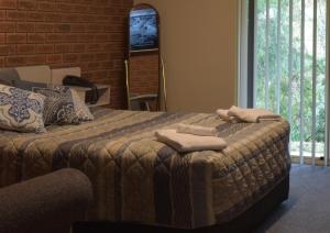 a bedroom with a bed with towels on it at Burra Motor Inn in Burra