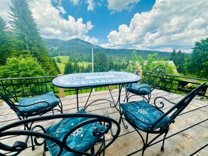 a table and chairs on a deck with a view at Mountain story apartment in Žabljak