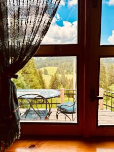a window with a view of a deck with a table at Mountain story apartment in Žabljak +40 photos