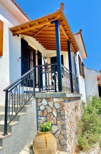 a house with a balcony and a vase on the stairs at Betsanis Stafylos Apartments in Stafylos