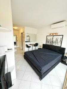 a bedroom with a large black bed in a room at #T03 DUCAL MARINA BAIE DES ANGES avec Terrasse in Villeneuve-Loubet