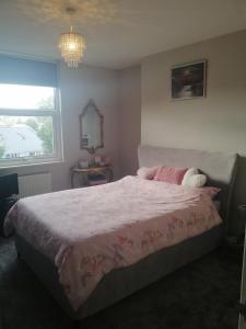 a bedroom with a bed with a pink comforter and a window at BNB Retreat Broadstairs Kent in Kent +2 photos