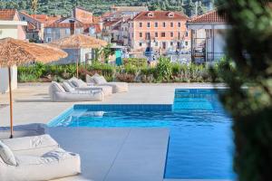 a pool with couches and umbrellas next to a building at Hvar luxury Villa and pool with view in heart of Stari Grad in Stari Grad