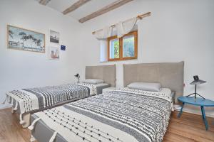 two beds in a room with white walls and a blue table at Hvar luxury Villa and pool with view in heart of Stari Grad in Stari Grad +19 photos
