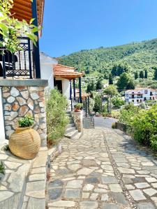 a stone walkway leading to a house at Betsanis Stafylos Apartments in Stafylos