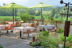 a restaurant with tables and umbrellas in a garden at Ferienwohnungen Theresienhof in Ledenitzen
