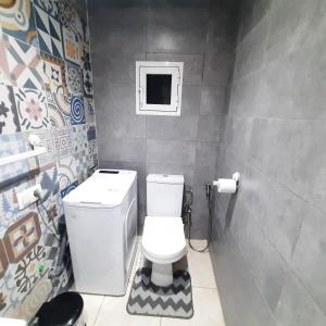 a bathroom with a toilet and a small window at Le clapotis de la mer in Kenitra +21 photos