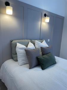 a bed with a bunch of pillows on it at Duplex raffiné, élégant & climatisé - La MEZZ in Nîmes