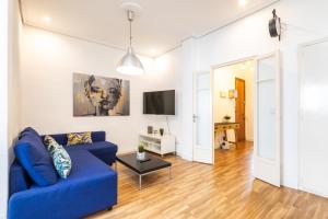 a living room with a blue couch and a tv at Mestalla River Apartment in Valencia