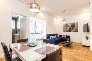 a living room with a table and a blue couch at Mestalla River Apartment in Valencia