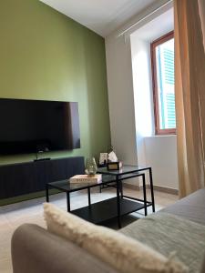 a living room with a tv and a coffee table at Duplex raffiné, élégant & climatisé - La MEZZ in Nîmes