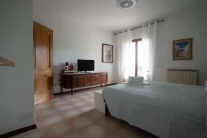 a bedroom with a bed and a television in it at holiday House Na Te in Riccò del Golfo di Spezia