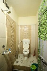 a small bathroom with a toilet and a shower at Rai Guest House in Ujjain