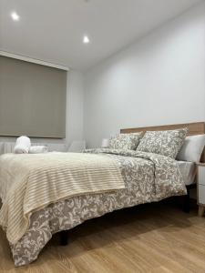 a white bedroom with a large bed and a television at Alesamar A in Burela de Cabo