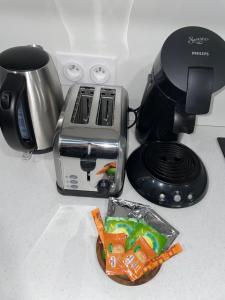 a kitchen counter with a toaster and a plate of food at Duplex raffiné, élégant & climatisé - La MEZZ in Nîmes +12 photos