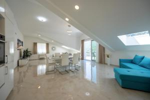 a living room with a blue couch and a dining room at The Golden Luxury Apartments in Kotor