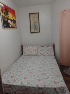 una camera da letto con un letto con copriletto floreale di Apartamento Cond. Privê em Caiobá 2 quadras da beira mar próximo ao Restaurante Casa do Camarão a Matinhos