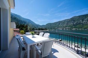 a table and chairs on a balcony with a view of the water at The Golden Luxury Apartments in Kotor