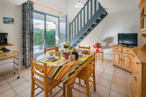 a kitchen and dining room with a table and chairs at Lagrange Vacances Les Maisonnettes in Sainte-Marie-Plage