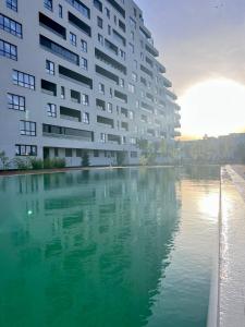 a large building next to a large body of water at Apartament Vivo & Pool access - Free parking in Constanţa
