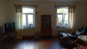 un soggiorno con 3 finestre e una TV di Ferienhaus mit Garten im Odenwald zu vermieten a Fränkisch-Crumbach