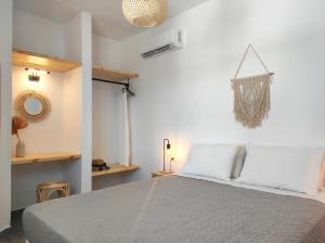 um quarto com uma cama grande e almofadas brancas em Rhodes Soul luxury suites em Afantou
