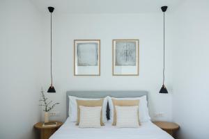 a bedroom with a bed with white sheets and pillows at Villa Olea - villa with heated pool, sauna and gym in Kaštela +68 photos
