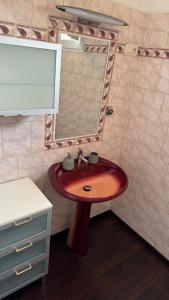 a bathroom with a red sink and a mirror at Appartement T4 in Corte +6 photos