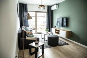 ein Wohnzimmer mit einem Stuhl und einem TV in der Unterkunft Apartamenty Fala in Międzywodzie