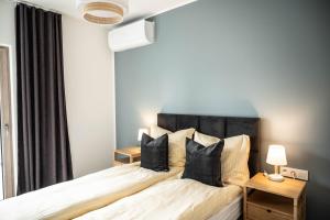 ein Schlafzimmer mit einem großen Bett mit schwarzen Kissen in der Unterkunft Apartamenty Fala in Międzywodzie