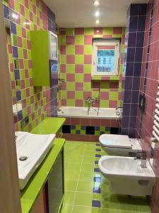 レンボルクにあるApartament Park Lęborkのカラフルなバスルーム(洗面台2台、トイレ付) +15枚の写真