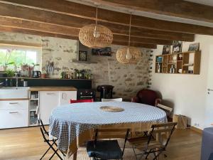 a kitchen with a table and chairs in a room at Maison en bord de mer - Plougastel-Daoulas - 6 à 8 personnnes in Plougastel-Daoulas +9 photos