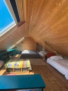 a large room with two beds and a blue table at Maison en bord de mer - Plougastel-Daoulas - 6 à 8 personnnes in Plougastel-Daoulas