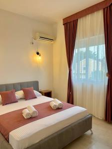 a bedroom with a large bed with towels on it at Street Apartments in Ulcinj