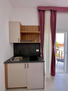 a kitchen with a counter with a sink and a window at Street Apartments in Ulcinj +43 photos